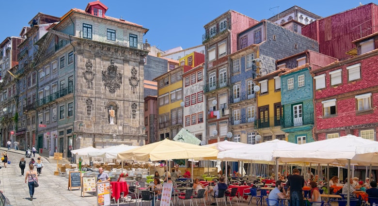 PORTO, PORTUGAL - JUNE 5, 2015: Colorful houses and outdoor cafes at historic Ribeira Square of Porto, a popular place for tourists and locals., License Type: media, Download Time: 2025-02-25T21:56:50.000Z, User: katelyn.perry_lonelyplanet, Editorial: true, purchase_order: 65050 - Digital Destinations and Articles, job: wip, client: wip, other: katelyn perry
